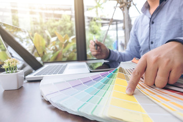 Poster - Creative creativity graphic designer working with graphics tablet,laptop and smart phone, colour chart at workplace on wooden desk , colour ideas style concept