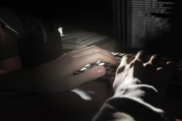 Programmer's hands on the keyboard, dark background