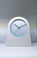 Wall Mural - Modern white and blue clock on white table