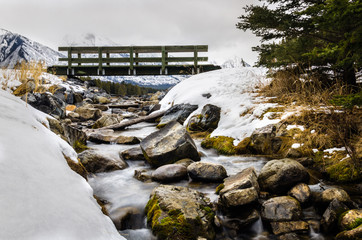 Small Wooden Bridge over a Mountain Creek in Winter. Banff National Park, AB, Canada.