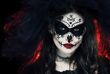 Close Up Studio Portrait Of Beautiful Woman With Halloween Sugar Skull Makeup In Red And Black Colors, Wearing Bridal Veil. Model Looking At Camera. Dark, Dead Bride. 
