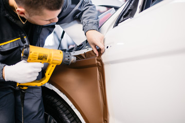 Wall Mural - Car wrapping specialist putting vinyl foil or film on car.