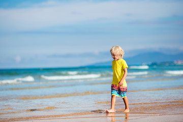 Wall Mural - Child on tropical beach. Sea vacation with kids.