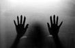 © zilvergolf - Shadowy figure behind glass. Fear and panic concept. Black and white tone.