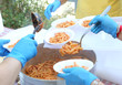 hands with latex gloves during meal distribution of pasta with t