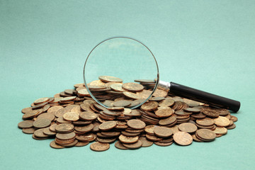 Wall Mural - magnifying glass on a heap of coins