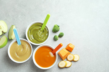 Sticker - Bowls with baby food on grey background