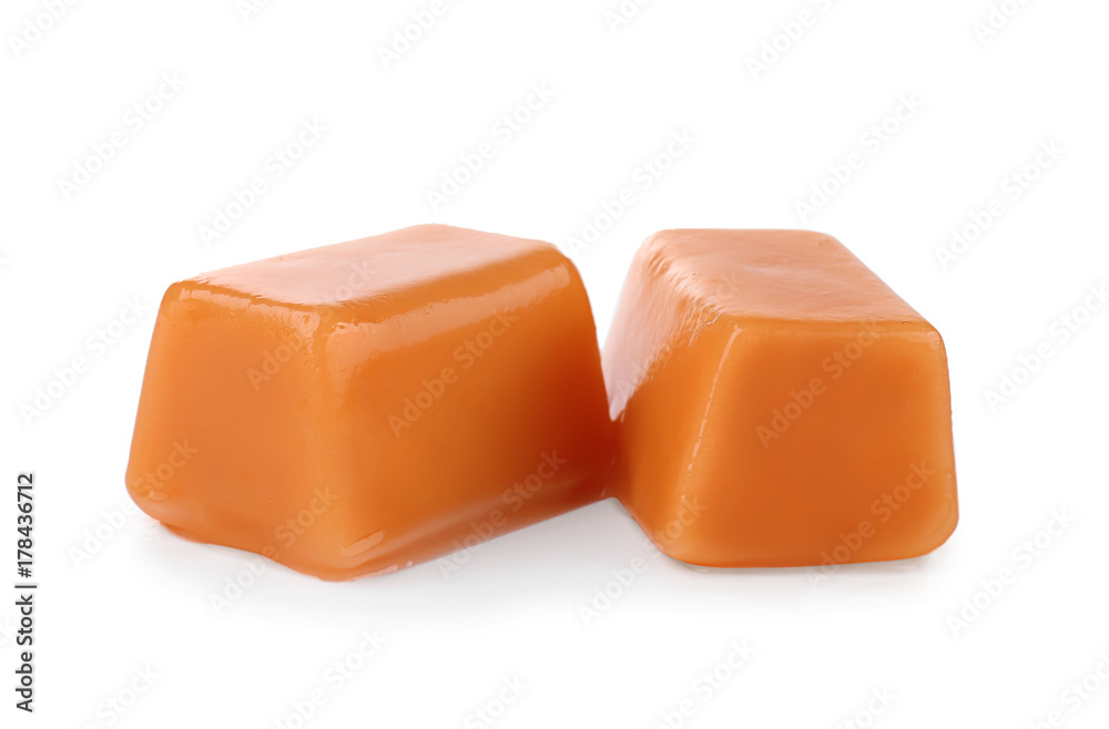 Sweet caramel candies on white background