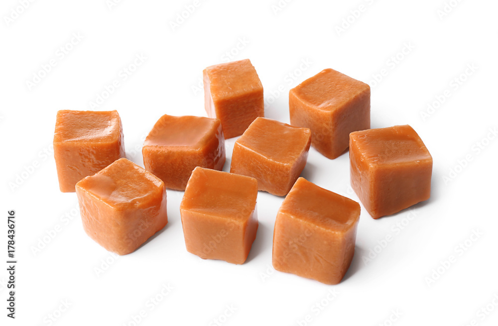 Sweet caramel candies on white background