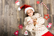 © javiindy - Adorable little girl wearing santa hat laying on wooden floor