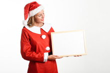Smiling Blonde Woman In Santa Claus Clothes With White Board
