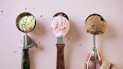 Wall Mural - Variety of metal ice cream scoops with different ice cream and toppings on pink background