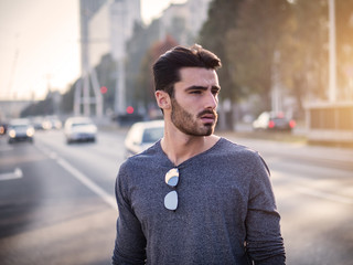 Wall Mural - Attractive young bearded man portrait in urban environment, in a street