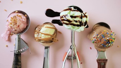 Wall Mural - Variety of metal ice cream scoops with different ice cream and toppings on pink background