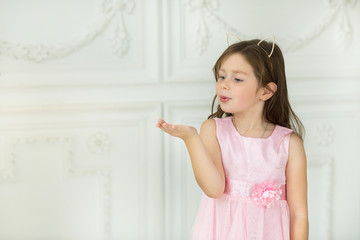 beautiful little smart girl in a dress on a white background