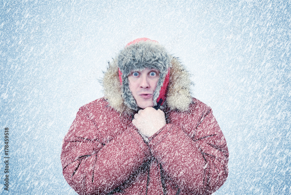 Frozen man in winter clothes warming hands, cold, snow, blizzard - obrazy, fototapety, plakaty 
