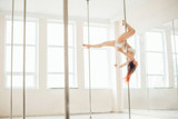 Young sexy pole dance woman. Bright white colors.