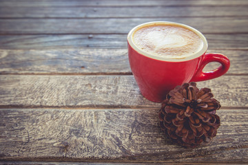 Wall Mural - cup of coffee on wood table with pine cone