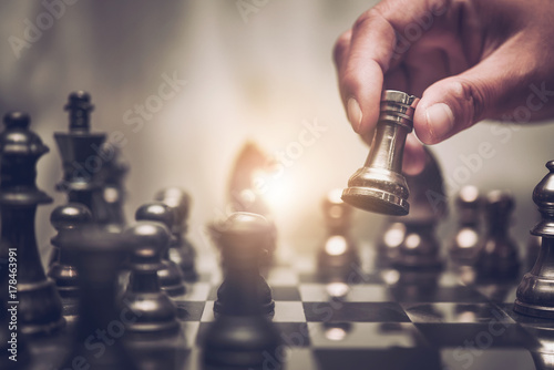 Fotomural Businessman moving chess piece on chess board game concept for ideas and competition and strategy, business success concept, business competition planing teamwork strategic concept