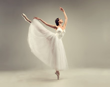 Ballerina. Young Graceful Woman Ballet Dancer, Dressed In Professional Outfit, Shoes And White Weightless Skirt Is Demonstrating Dancing Skill. Beauty Of Classic Ballet.