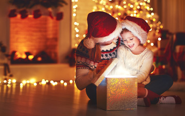 Wall Mural - merry christmas! family mother and child with magic gift at home