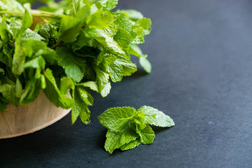 mint leaf. Green fresh mint, selective focus. Bunch of Fresh green organic mint leaf closeup. Peppermint. Natural light. Selective focus. Close up on a black background. Top view, flat lay. copy space