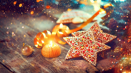 Poster - Christmas gingerbread cookies on wooden table decorated with garland and candles