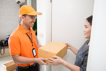 Asian Woman Accepting A Delivery Of Boxes From Deliveryman