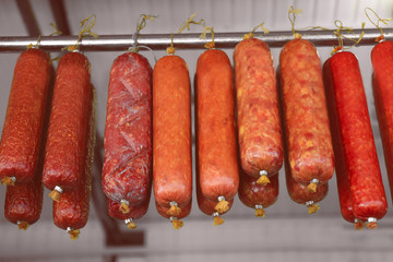 Poster - Assortment of sausages hanging on rack at market