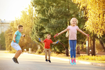 Wall Mural - Adorable children skipping rope outdoors