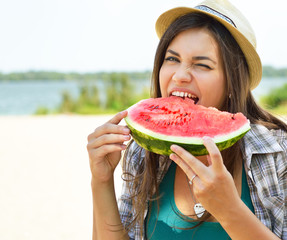 Wall Mural - Happy young woman eating watermelon on the beach. Youth lifestyle. Happiness, joy, holiday, beach, summer concept.