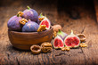 Figs and walnuts.. A few figs and walnuts in a bowl on an old wooden background
