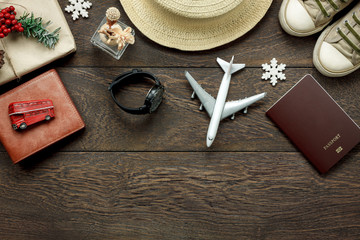 Wall Mural - Above view shot of accessories fashion lifestyle to travel and Merry Christmas & Happy new year concept.Passport & clothes with many essential winter season background.Several objects on brown plank.