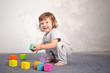 © olharozova - Little happy girl playing with toy on floor. Kindergarten.