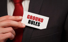 Businessman Putting A Card With Text GROUND RULES In The Pocket