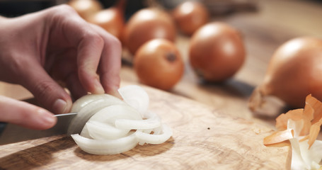 Wall Mural - young female hands slicing white onion