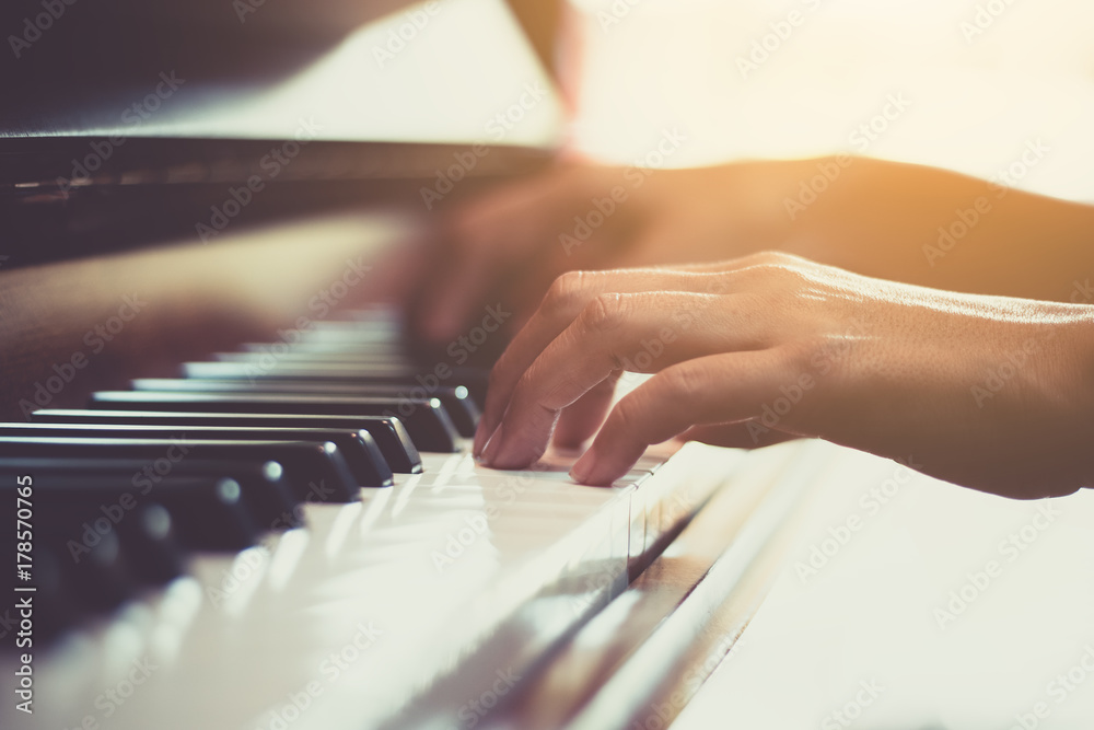 Close up of happy woman's hand playing the piano in the morning. - obrazy, fototapety, plakaty 