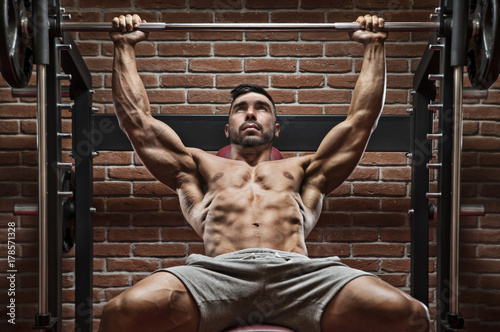 Zdjęcie XXL Bodybuilder trening dla klatki piersiowej z ściana z cegieł na tle.