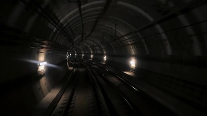 Wall Mural - View of subway tunnel as seen from the rear window of moving train. Fast underground train departs from modern subway station. Timelapse of an underground train following its route