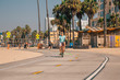 Young man riding a beach bike down the Venice beach in Los Angeles near Santa Monica pier.