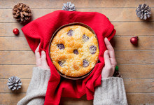 Female Hands Holding Christmas Pie In Red Towel