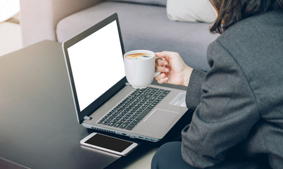 Aufkleber - Businesswoman holding coffee cup working on laptop and mobile at office,Mock up blank white screen computer for display of design content,Digital marketing business concept.