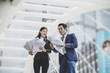 © Johnstocker - Business colleague talking and viewing documents outdoor