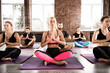 © alphaspirit - Yoga meditation of young people in lotus pose in fitness center