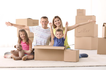 Poster - Happy family unpacking cardboard boxes in room at new house