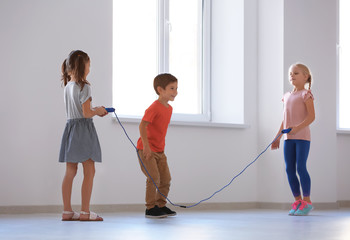 Canvas Print - Adorable children skipping rope indoors