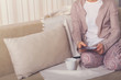 © tirlik - girl on the couch with a tablet.Young woman using smartphone at home on the couch