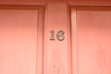 House Number 16 Sign On Orange Painted Door