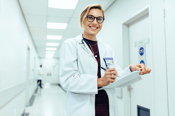 Healthcare worker in hospital hallway with medical report