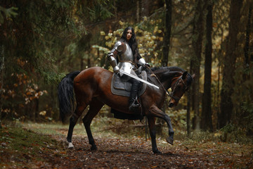 Portrait of beautiful medieval girl warrior in a chain mail hood.